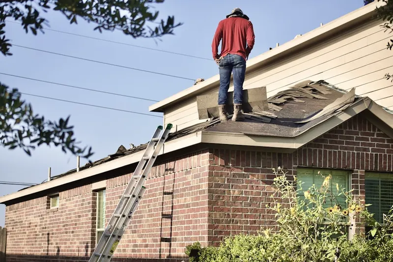 Professional roofer working on a residential roof in Thompsonville